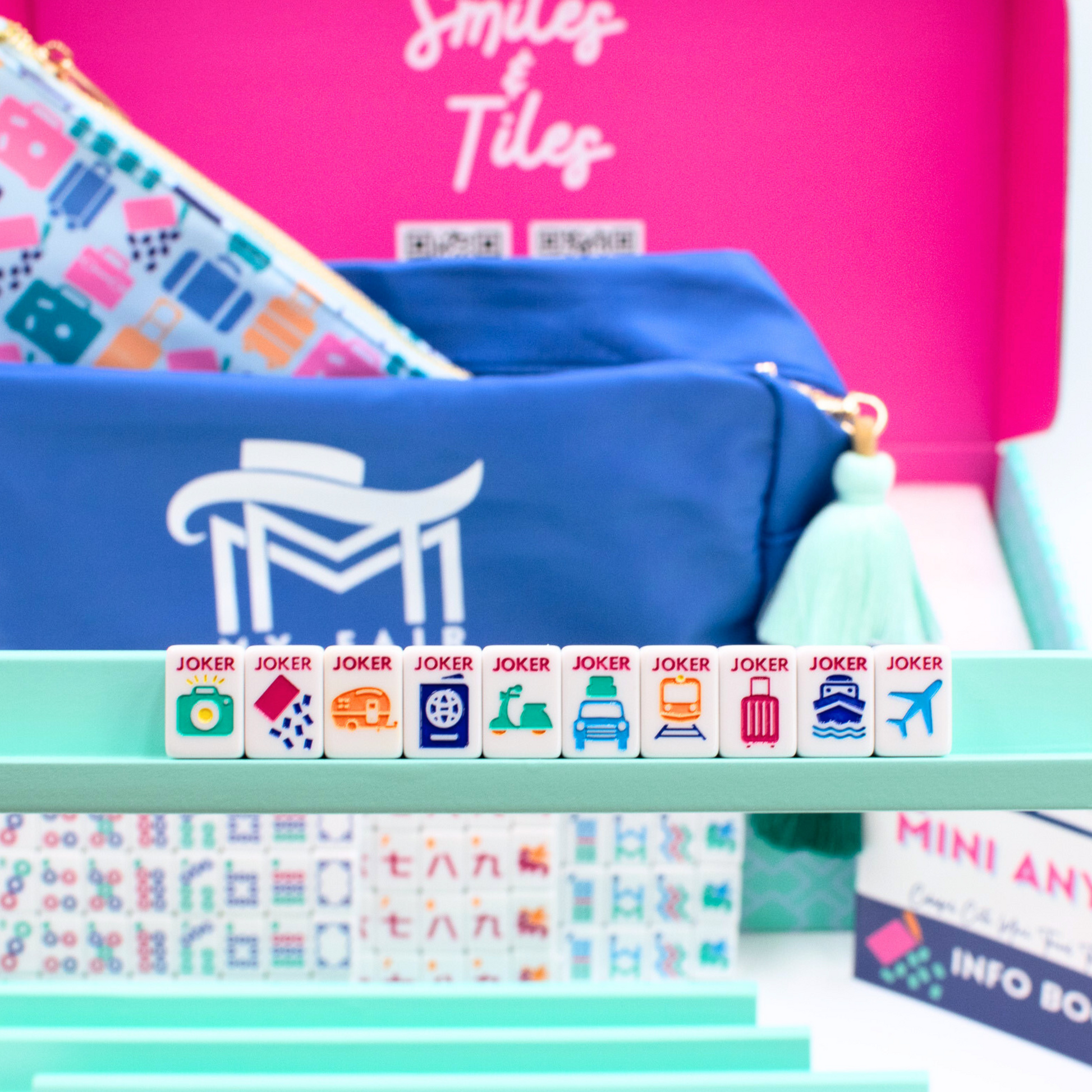 Mini Travel Mahjong jokers held on a blue mini wooden rack in front of product packaging.